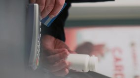 Vertical video: Clients buying pharmaceutical products at cash register desk, paying with smartwatch, mobile phone with nfc and credit card. Customers having pills and medicaments at counter. Close up - Powered by Shutterstock - Get 15% off with code: PIKWIZARD15