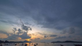 time lapse beautiful sunrise above fishing boats on Rawai beach, Phuket,Thailand.
light through the cloud to sky above fishing boats.
video 4K. Scene of Colorful red light in the sky background.