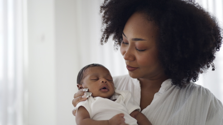Close up portrait of beautiful young African American mother holding kissing sleep newborn baby in hospital. Healthcare medical love black afro woman lifestyle mother's day, breast concept  Royalty-Free Stock Footage #1097386157