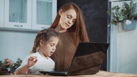 mother helps coronavirus schoolgirl a daughter with homework. adult parent tutor explains lessons lockdown distance homeschooling school. distance learning at home concept. mother and daughter