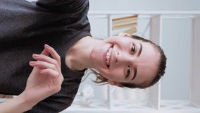 Vertical video. Vlogger interview. Online communication. Amused enthusiastic woman greeting waving hello blowing air kiss recording selfie live streaming at light home interior. - Powered by Shutterstock - Get 15% off with code: PIKWIZARD15