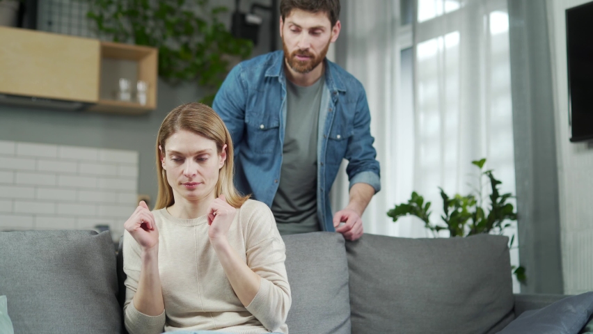 Aggressive young bearded man yells at his scared wife swung and threatens to beat Terrified woman close her ears and try to protect herself from an cruel husband at home Domestic violence abuse Royalty-Free Stock Footage #1097391083