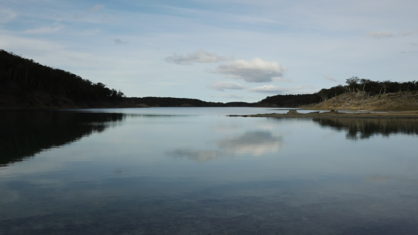 Panorama view of the tranquil lake and forest. Beautiful reflection of the environment and blue sky in the water surface. 
