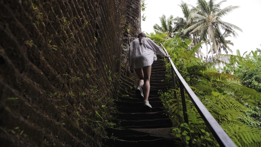 girl climbs the steps in Bali