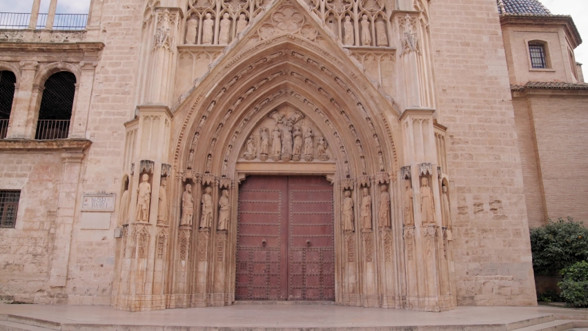 The camera moves towards the Gothic gate of the Valencia Cathedral in Spain Royalty-Free Stock Footage #1097397339