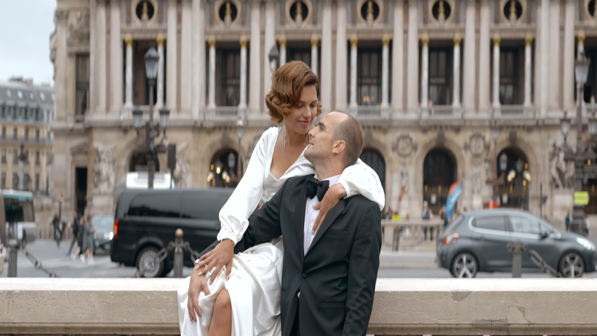 Loving couple video shooting on their wedding day. Action. Bride in white dress and groom in suit on the background of big city architecture. | Shutterstock HD Video #1097403785