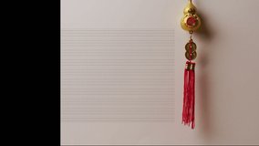 Animation of new year greetings text over chinese traditional decorations. Chinese new year, festivity, celebration and tradition concept digitally generated video.