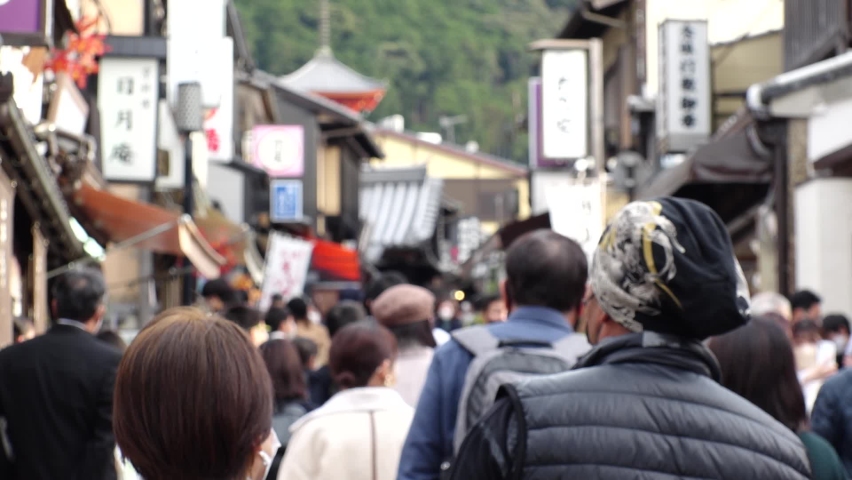 KYOTO, JAPAN - DECEMBER 2021 : View of crowd of people wearing masks to protect from Coronavirus (Covid-19). Tourists around Kiyomizudera (Kiyomizu Temple) in autumn leaves season. Slow motion shot. | Shutterstock HD Video #1097408139