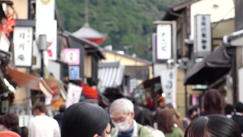 KYOTO, JAPAN - DEC 2021 : Back shot and crowd of people wearing masks to protect from Coronavirus (Covid-19). Tourists around Kiyomizudera (Kiyomizu Temple) in autumn leaves season. Slow motion shot. | Shutterstock HD Video #1097408143