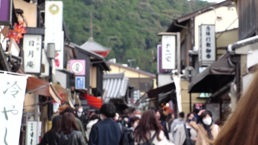 KYOTO, JAPAN - DEC 2021 : Back shot and crowd of people wearing masks to protect from Coronavirus (Covid-19). Tourists around Kiyomizudera (Kiyomizu Temple) in autumn leaves season. Slow motion shot. | Shutterstock HD Video #1097408157