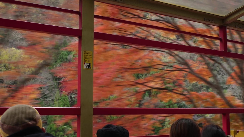 KYOTO, JAPAN - DECEMBER 2021 : View of riding on Sagano Romantic train (Sagano Scenic Railway) in Autumn leaves season. Saga torokko station to Kameoka torokko Station. | Shutterstock HD Video #1097408243