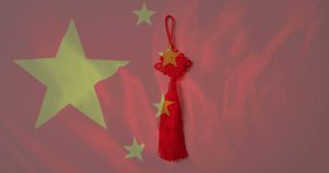 Animation of flag of china over chinese traditional decorations on red background. Chinese new year, festivity, celebration and tradition concept digitally generated video.