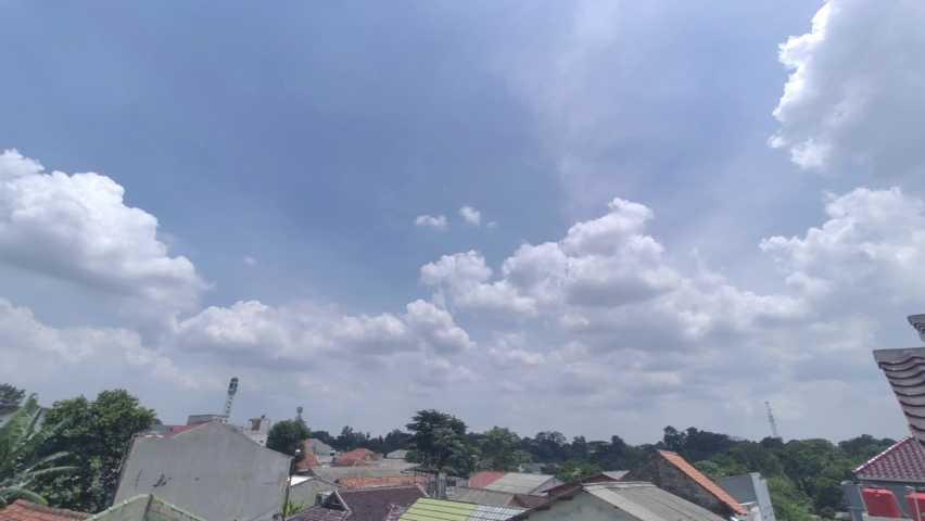 Time lapse of blue sky and white clouds over the roof of house in suburban area in South Jakarta | Shutterstock HD Video #1097409313