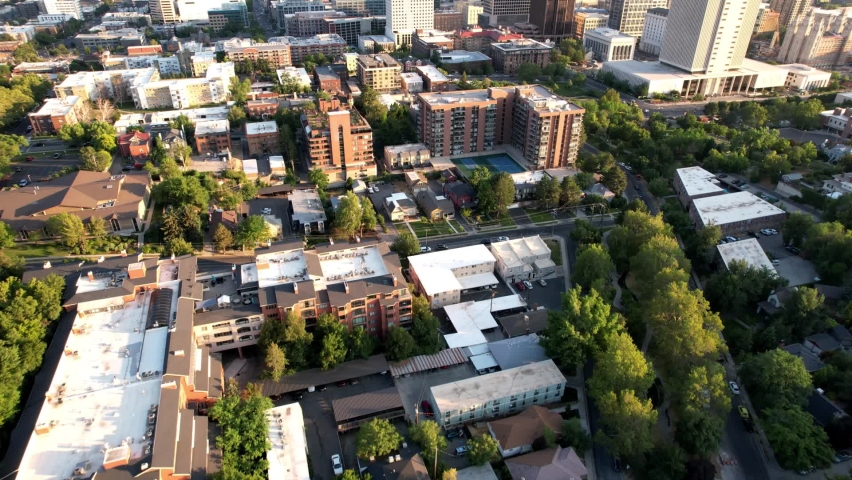 Aerial flyover Memory Grove Park and cityscape of Salt Lake City with high-rise buildings at sunset