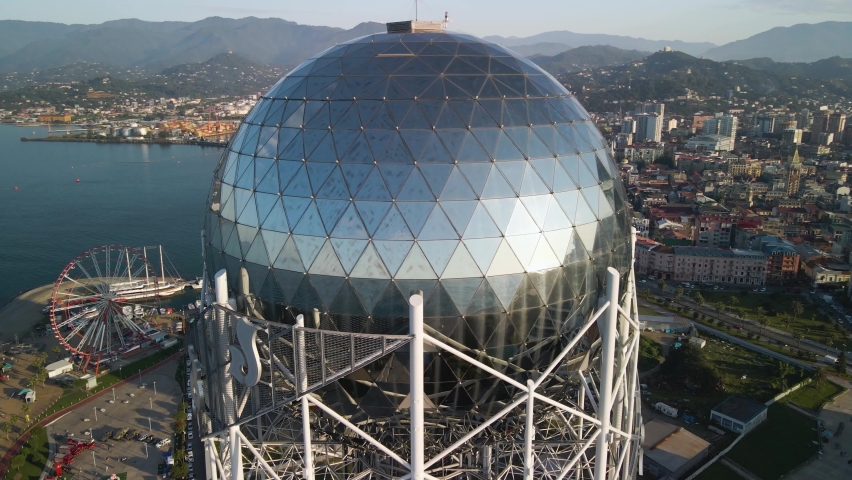 Aerial Orbit shot of the alphabetic tower besides a park in batumi Georgia