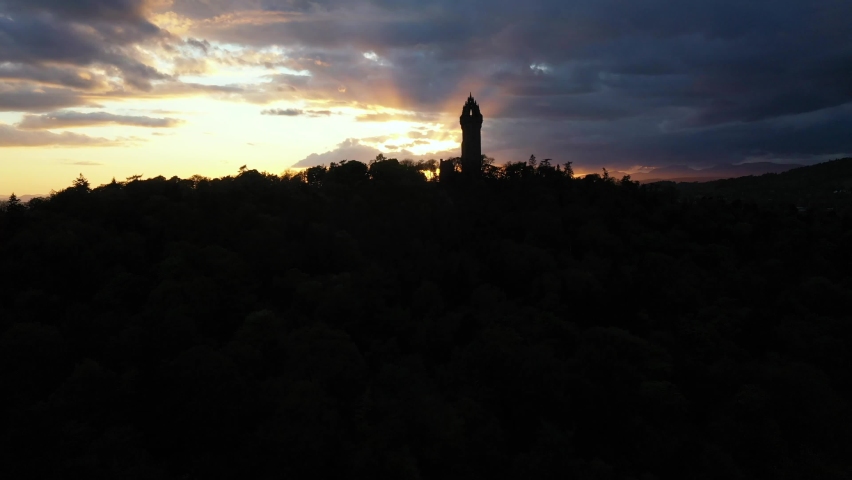 4K Aerial view from behind Wallace Monument at sunset in Stirling, Scotland