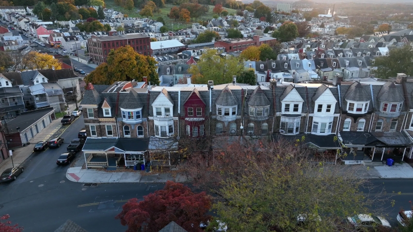 American city with historic old stone rowhouses. Aerial truck shot of residential district in USA downtown urban setting. Autumn leaves on trees.