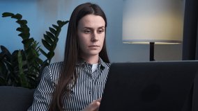 Close up of tired brunette woman massaging temples, suffering from headache after computer work, sitting on sofa with laptop at home. Exhausted female touching head, relieving pain, migraine concept