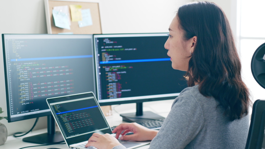 Young Asian woman, developer programmer, software engineer, IT support, working hard on computer to check coding in bugging system | Shutterstock HD Video #1097416683