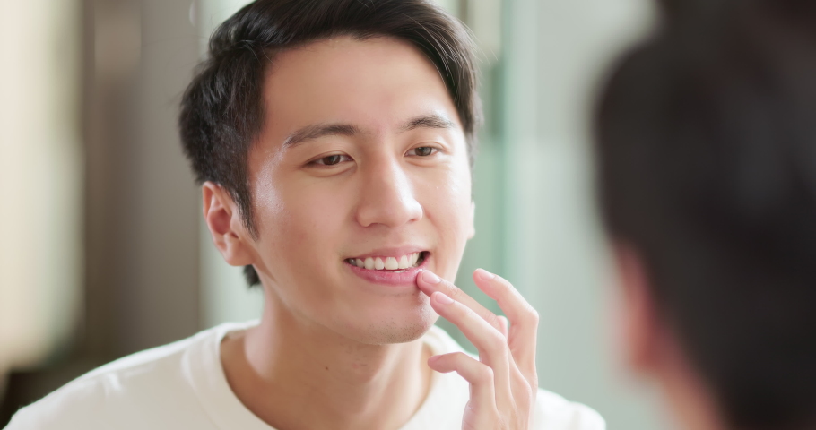 Asian man satisfied with his teeth infront of mirror being confident Royalty-Free Stock Footage #1097416937