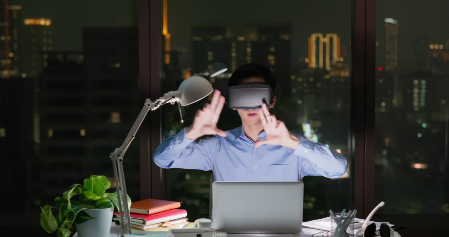 Asian business man sitting in office participating video conference using VR technology at night | Shutterstock HD Video #1097416965