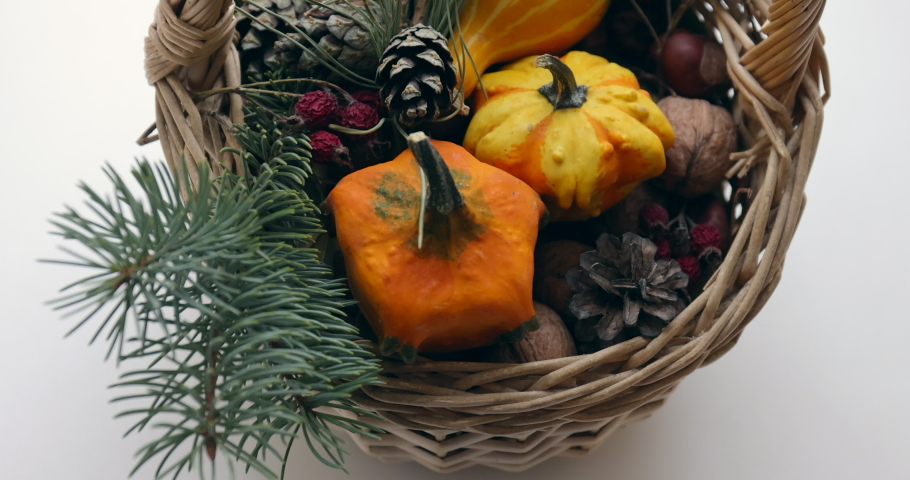 Camera tilt of a gift basket with pumpkin, walnuts, cones and sprigs of a Christmas tree | Shutterstock HD Video #1097417157