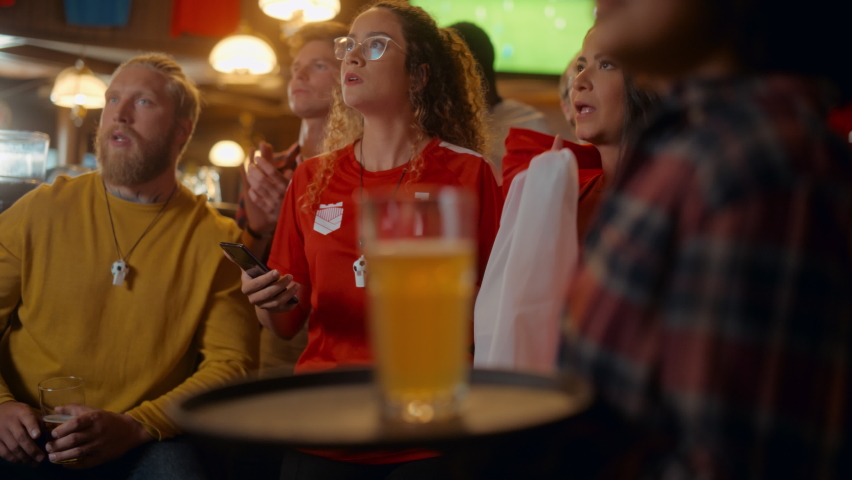 Portrait of an Anxious Multiethnic Female in Red Jersey Holding a Smartphone, Nervous About the Sports Bet on Her Favorite Soccer Team. Happy Victorious Emotions When Football Team Scores a Goal. Royalty-Free Stock Footage #1097419579