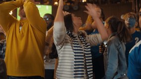 Group of Diverse Soccer Fans Cheering Their Team During a Football Game Live Broadcast in a Sports Pub. Anxious Crowd Saddened and Angry When Competitor Player Scores a Decisive Goal. - Powered by Shutterstock - Get 15% off with code: PIKWIZARD15