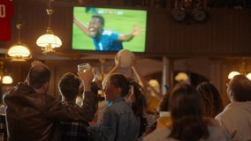 Group of Soccer Fans Cheering, Screaming, Raising Hands and Jumping During a Football Game Live Broadcast in a Sports Pub. Player in Blue Shirt Scores a Goal and Friends Celebrate. Slow Motion Footage - Powered by Shutterstock - Get 15% off with code: PIKWIZARD15