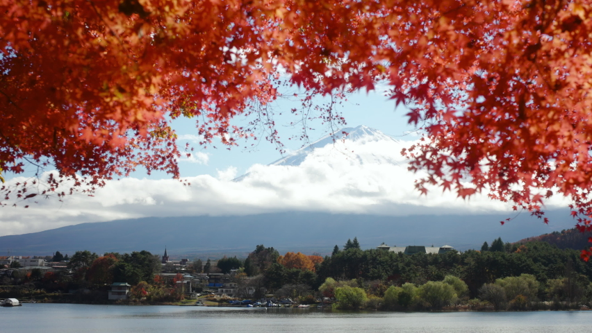 4K Landscape beautiful nature of lake Kawaguchiko with Mt Fuji covered in snow and red maple tree leaves in winter autumn season. Travel Japan scenery landmark famous place and season change concept.
