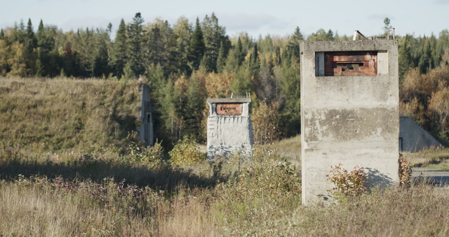 Two machinegun pill boxes stand guard at a special military security area with bunkers visible in the background.