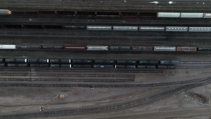 Top down of railroad train cars on tracks. Freight shipping railyard yard theme. Aerial view.