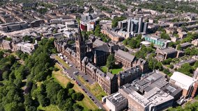 Aerial shot pulling back from Glasgow University over Kelvingrove Park on a sunny day