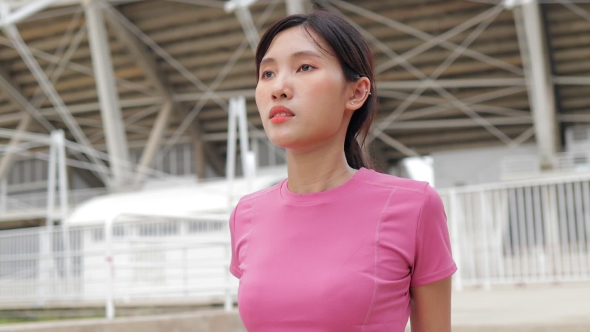 Young Asian woman exercising outdoors in the morning. Warm up before playing sports. Sports concept, health care
