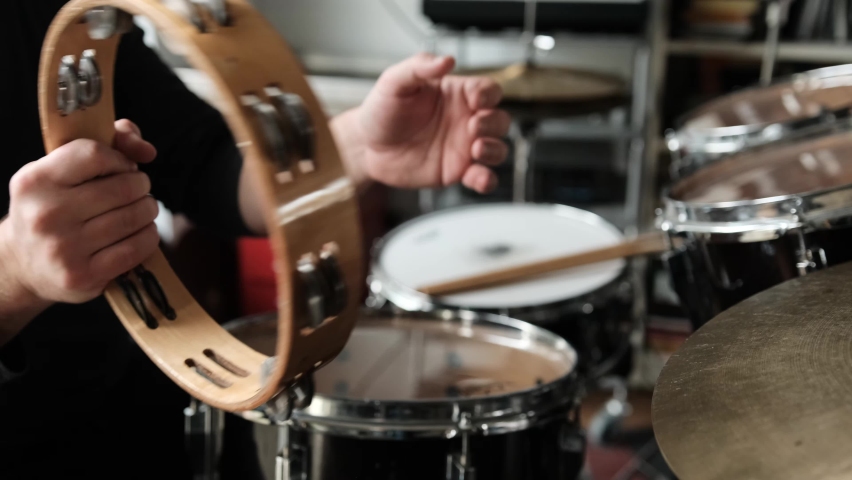 Man hands with tambourine in music recording studio. Guy playing on traditional folk musical instrument Royalty-Free Stock Footage #1097429335
