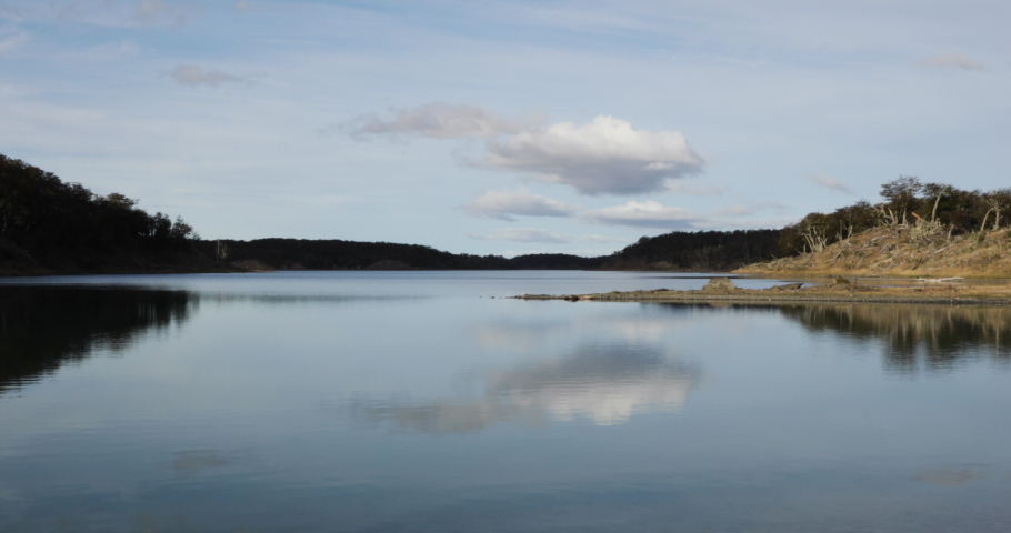 Panorama view of the tranquil lake and forest. Beautiful reflection of the environment and blue sky in the water surface. 