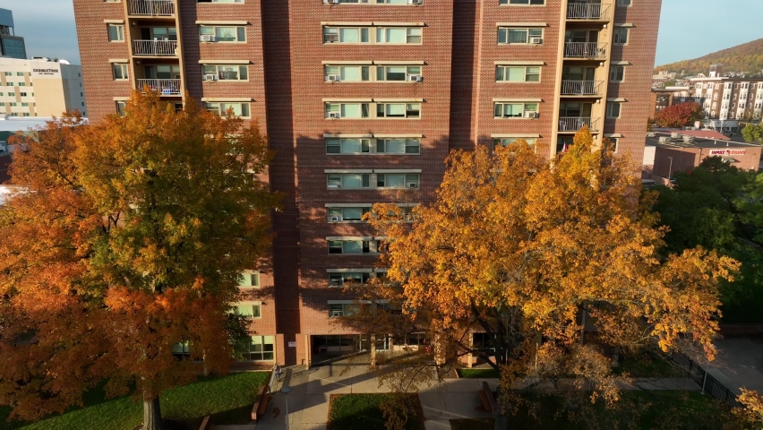Red brick apartment building in downtown USA city. Aerial in golden hour autumn view.