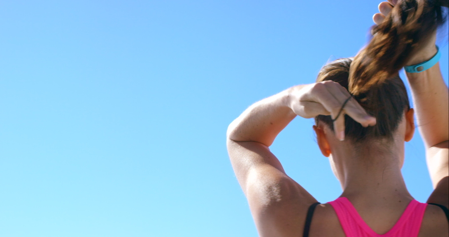 Blue sky, fitness and woman tie hair in ponytail ready for workout, running and exercise in summer. Wellness, health and back of girl with hairstyle before marathon training, sports and run outdoors Royalty-Free Stock Footage #1097440511