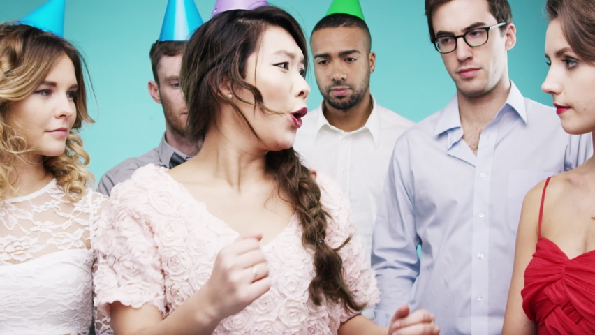 Dance, drunk and party with an asian woman in studio on a blue background with annoyed or unhappy friends. Birthday, awkward and fun with a female dancing or being weird with a man and woman group Royalty-Free Stock Footage #1097440603