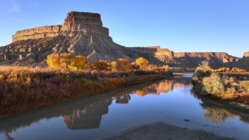 Flying over the Green River during Fall in Utah with golden trees along the riverbanks.
