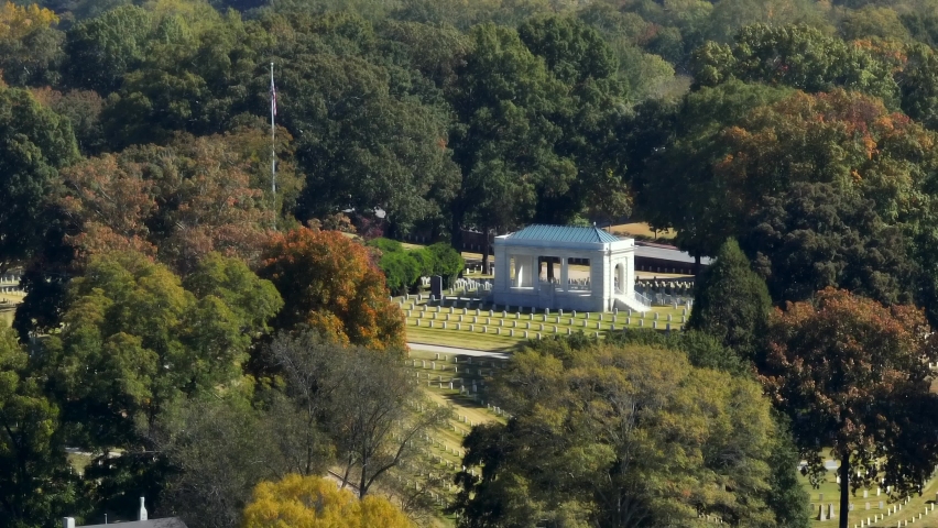 National Cemetery with American flag at rest. Monument honors service men and women lost in battle and war.