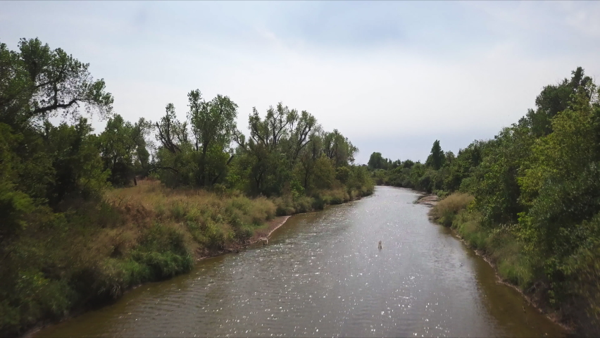 Aerial shot of a small river with brown water from a heavy rain