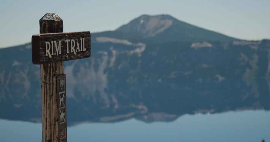 Trailhead sign rack focus to lake and mountains in the background