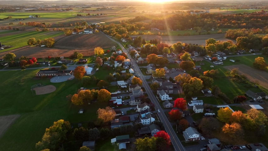 Beautiful nature scene in autumn. Small village surrounded by rural agriculture farmland fields in USA.