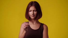 4k video of one girl in panic on yellow background.