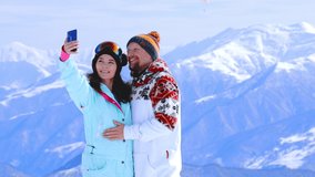 Portrait of cheerful couple snowboarders having fun outdoor. Happy young people take selfie in snowy mountains. Joyful man and woman spending winter Christmas holiday together. Active sport concept - Powered by Shutterstock - Get 15% off with code: PIKWIZARD15