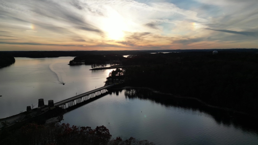 sunset over lake with bridge and boat