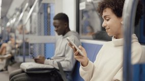 young woman using a smartphone on a subway train.