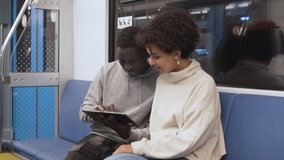 student friends use a digital tablet while riding the subway . - Powered by Shutterstock - Get 15% off with code: PIKWIZARD15