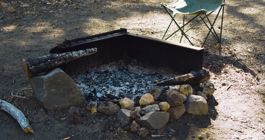 Ashes of a camp fire next to chair